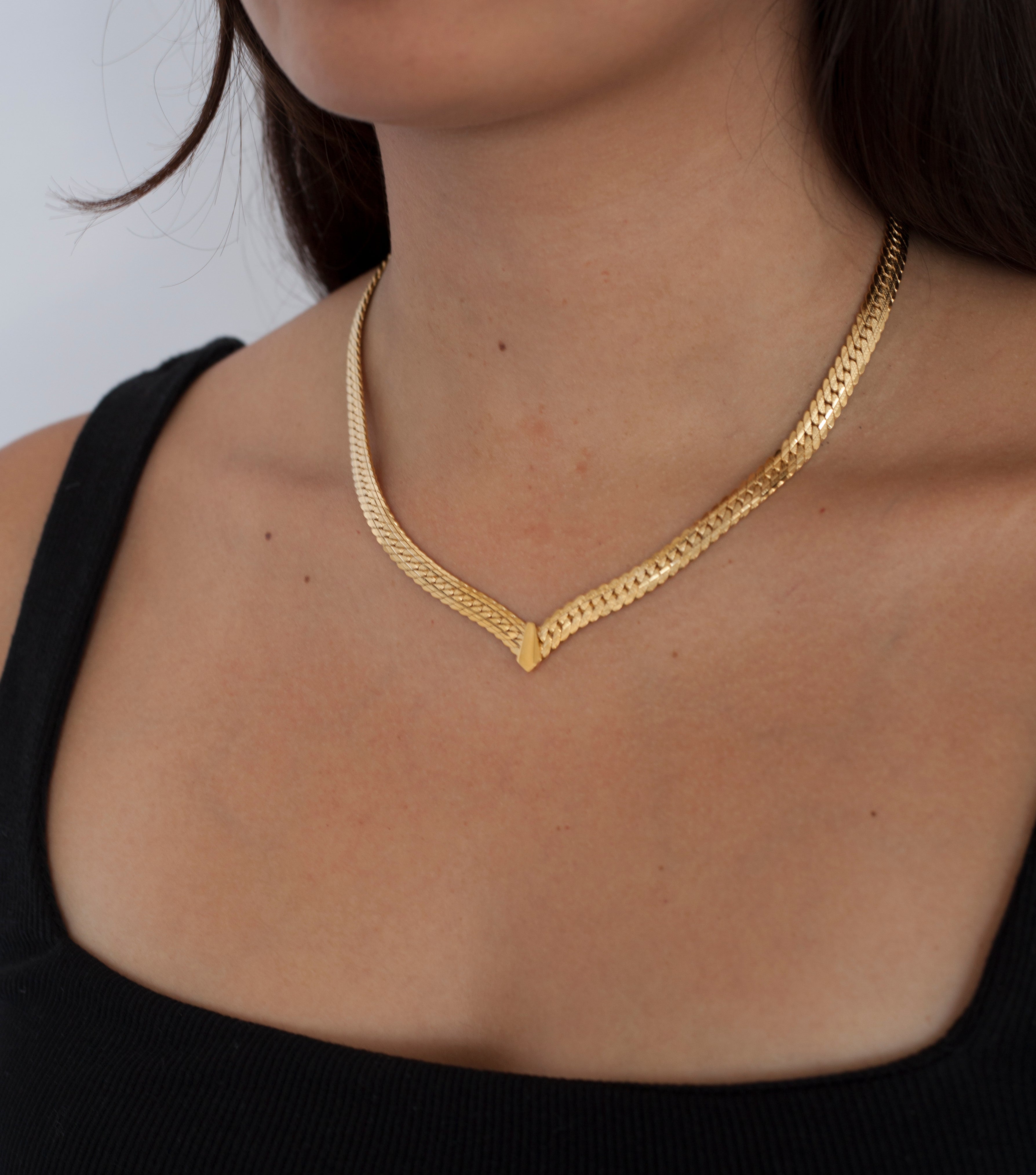model wearing Thick Snake Chain Necklace with a detailed point and fold over clasp closure.