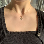 Gold square shaped zodiac pendant with diamond cut details on a thin curb chain
