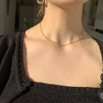 Thin figaro chain necklace on model