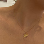 model wearing 10K Gold 'Baby Boy' pendant on a thin curb chain